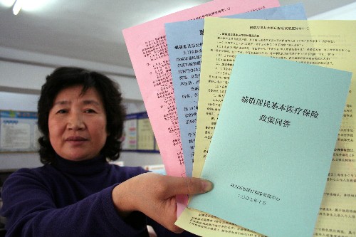 2007年11月6日,在哈爾濱市道里區工程街道辦事處勞動保障事務所,工作人員在展示哈爾濱城鎮居民基本醫療保險政策宣傳材料。 醫療、養老、住房、教育,百姓生活總繞不開的這些事,由于體制機制的有待完善,有時讓人頗感頭疼。2007年,在“以人為本”的政策指引下,隨著經濟快速發展和政府財力不斷增強,國家頻頻出臺一系列改善民生的新舉措,使經濟發展的成果普惠大眾。 新華社發