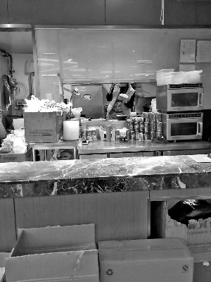 餐廳員工用筷子從外賣(mài)盆中夾菜吃。